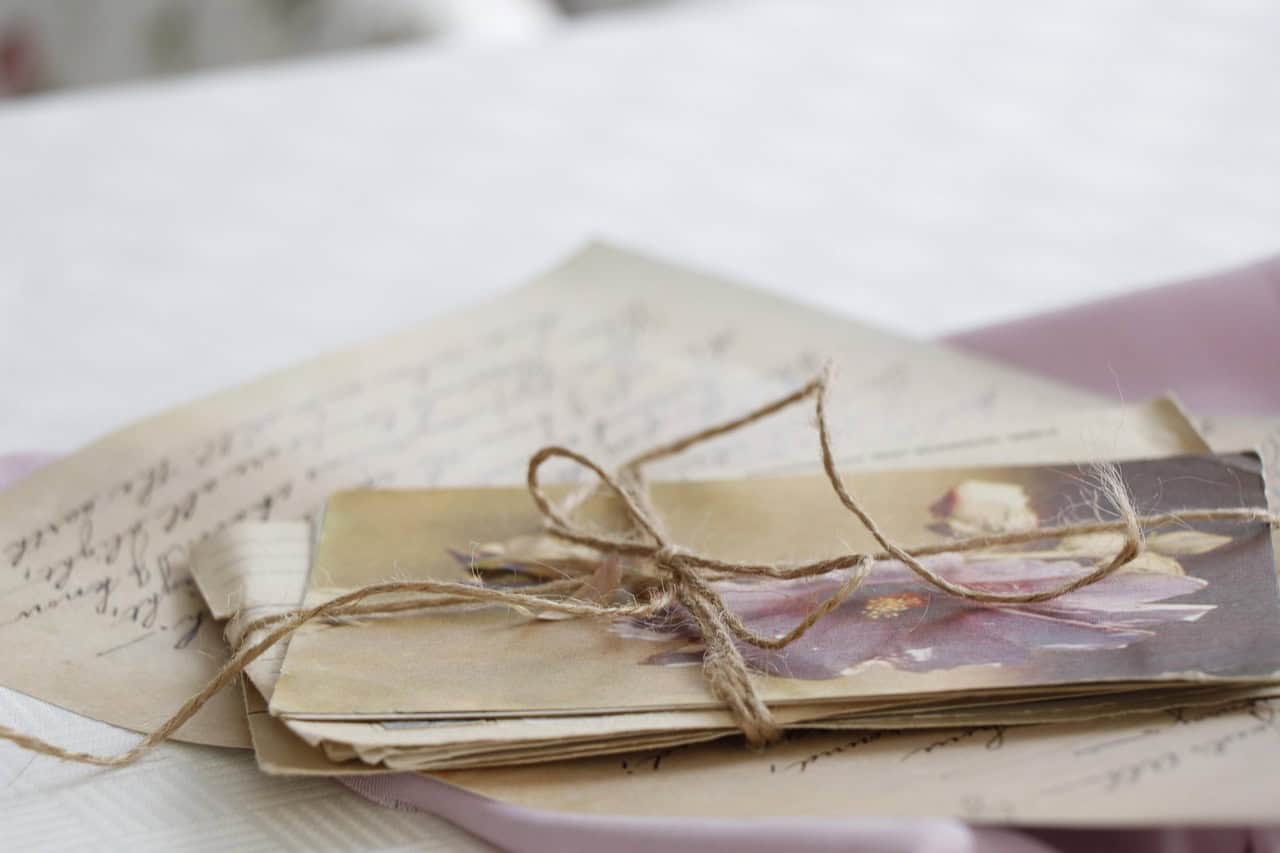 Collection of vintage handwritten letters and photographs tied with twine.